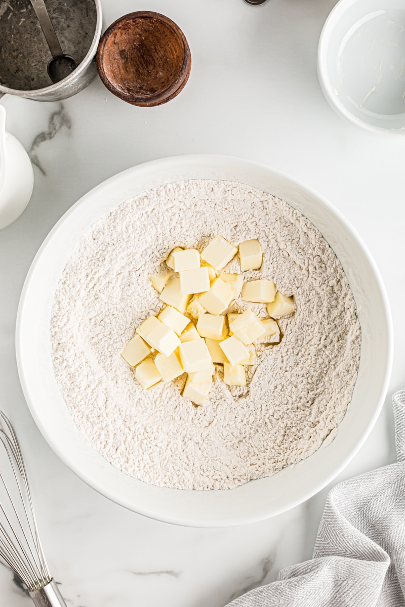 overhead view of butter added to flour mixture for pie crust