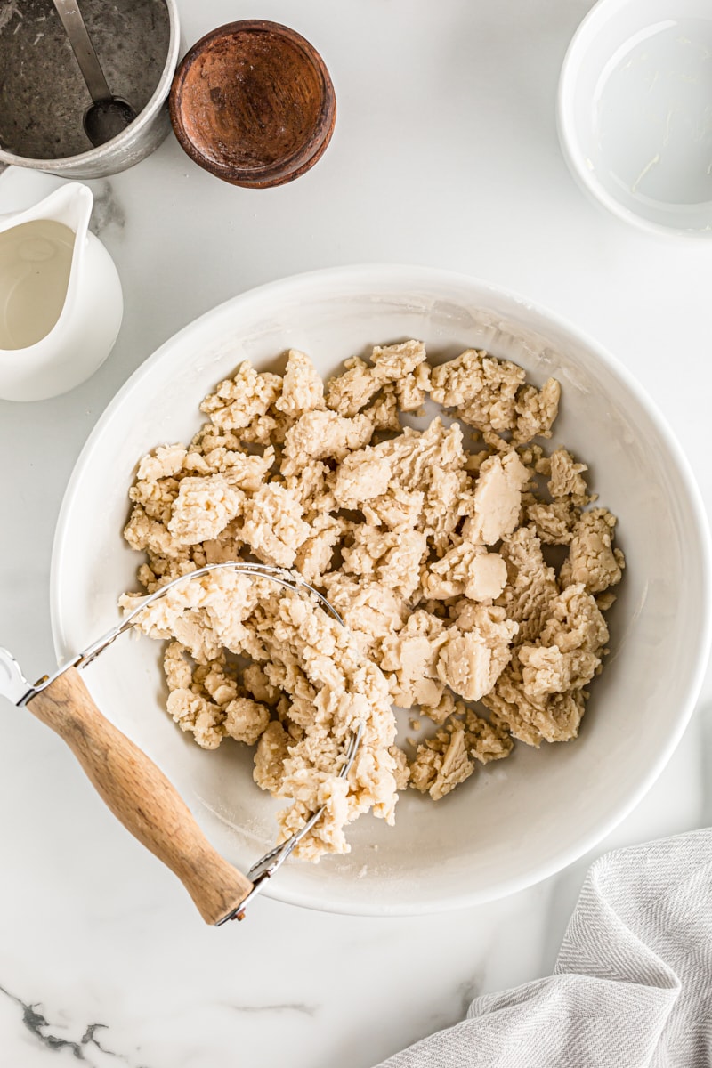 overhead view of pie crust mixture in a white mixing bowl