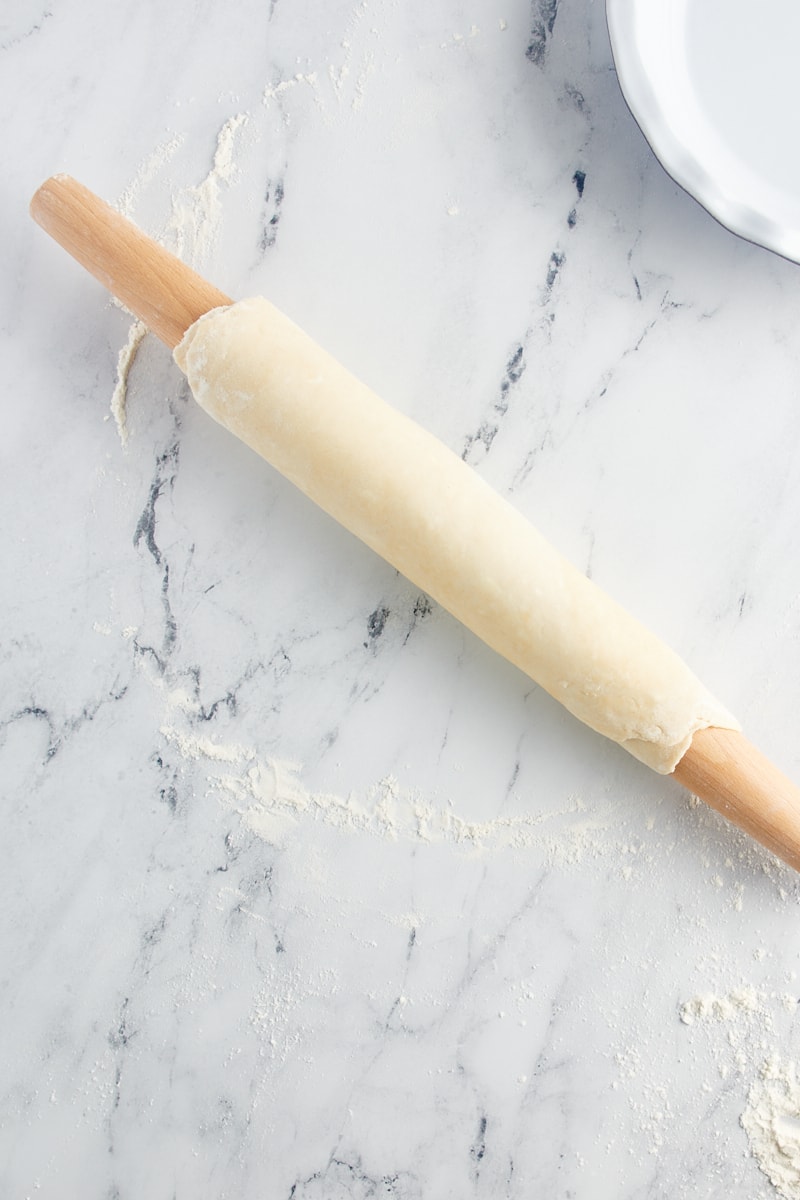 overhead view of pie crust dough wrapped around a rolling pin