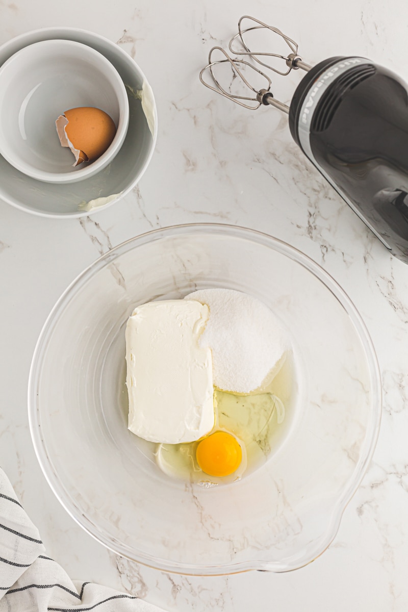 Butter, sugar, and egg in a glass mixing bowl.