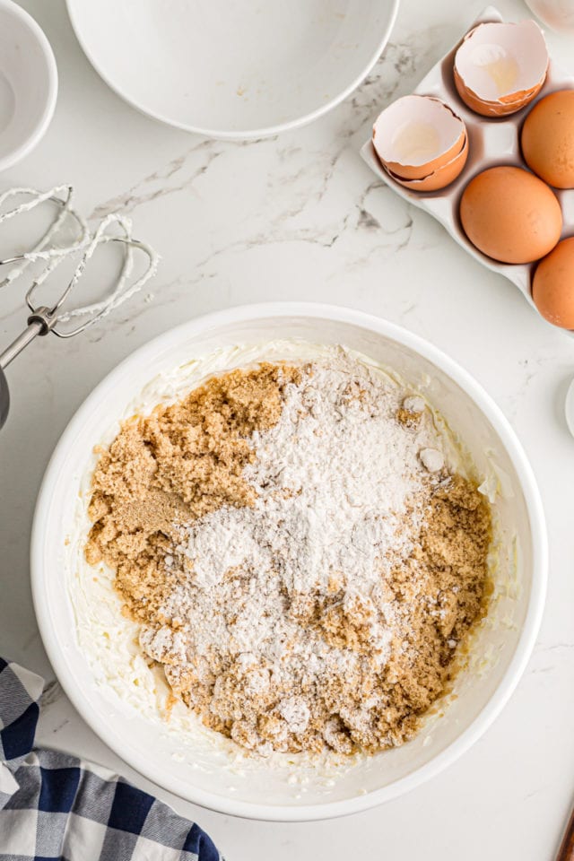 Adding dry ingredients to cream cheese.