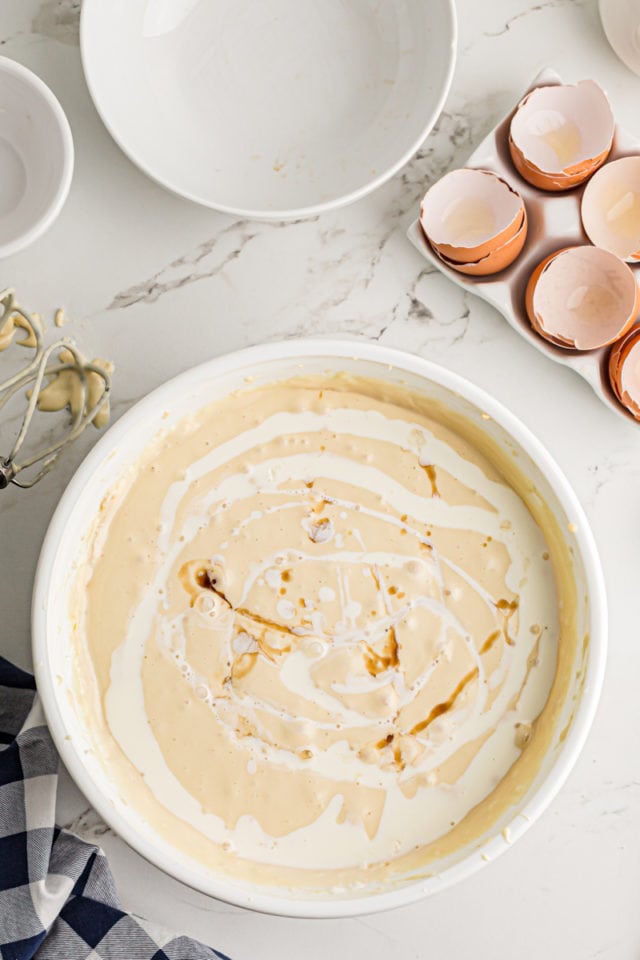 Adding vanilla and heavy cream to the cheesecake batter.