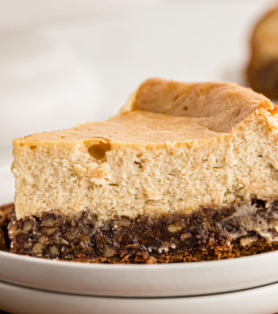 A slice of pecan pie cheesecake on a white plate