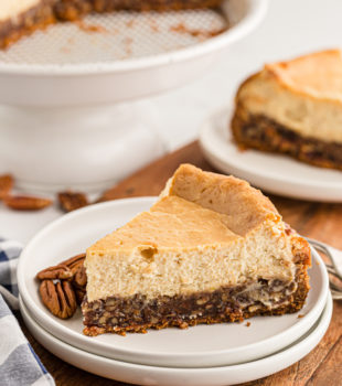 Pecan pie cheesecake slice in front of the rest of the pie