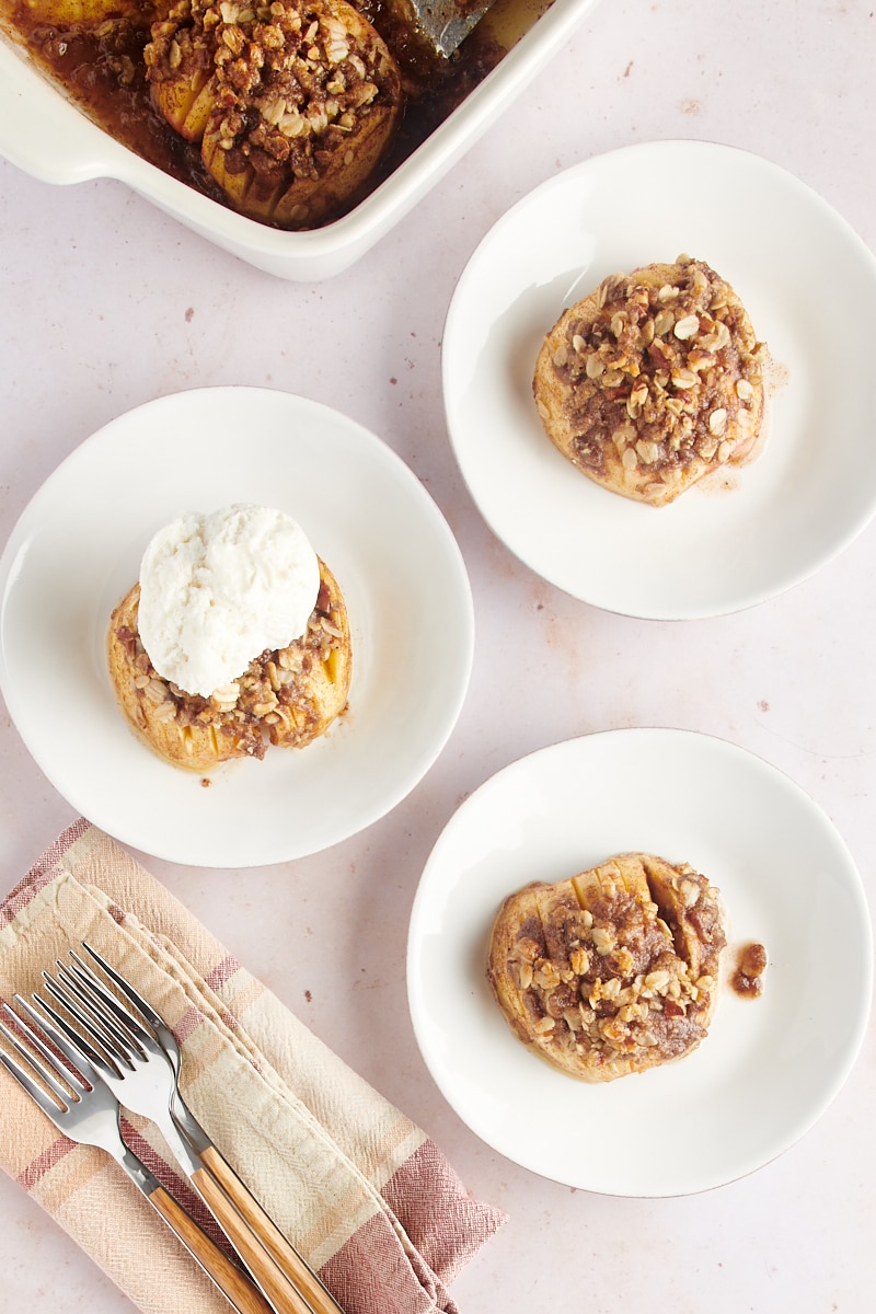 overhead view of baked hasselback apples served on white plates