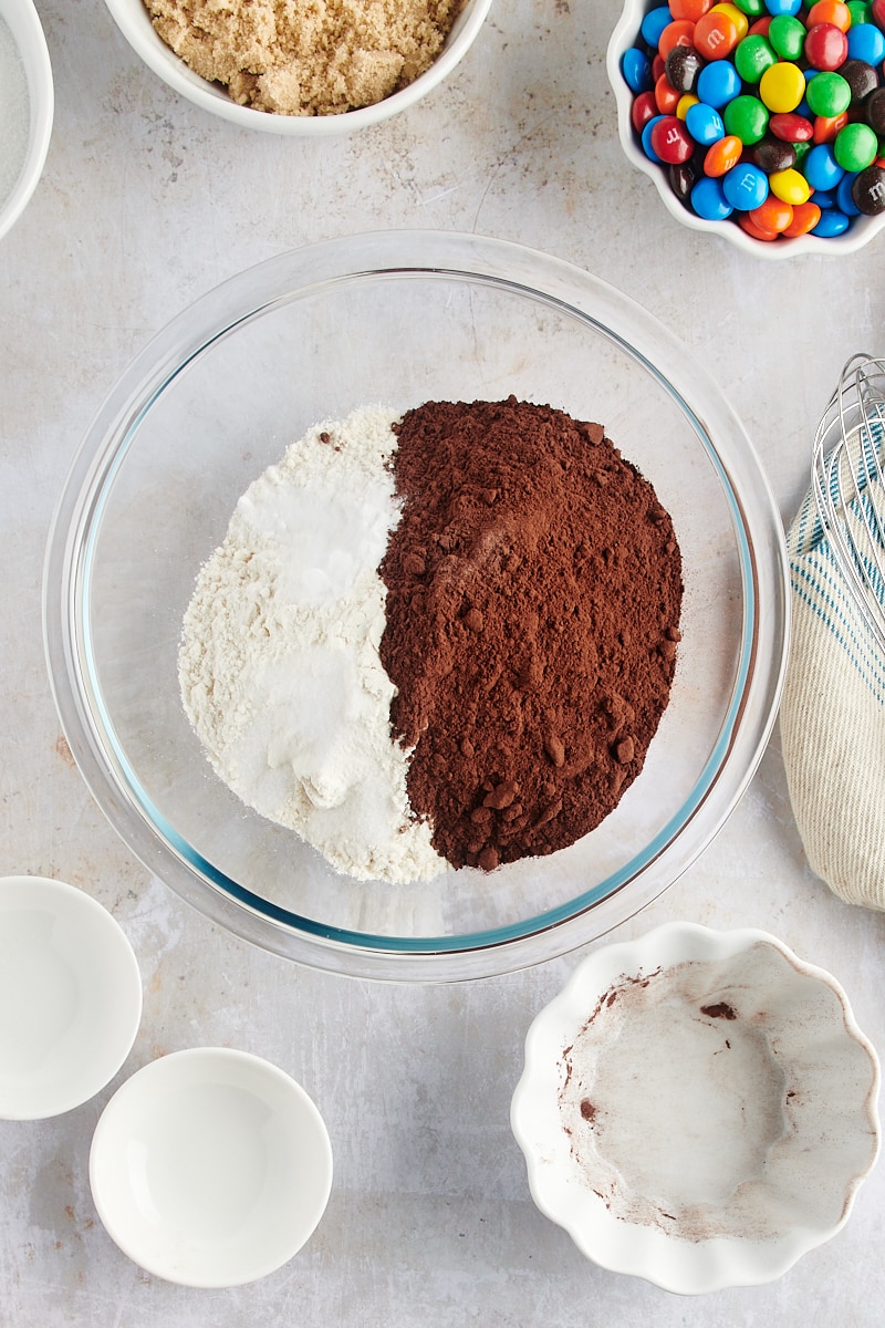 overhead view of flour, cocoa powder, baking soda, and salt in a glass mixing bowl