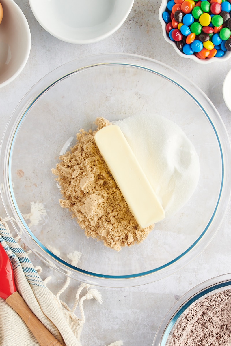 overhead view of butter, sugar, and brown sugar in a glass mixing bowl