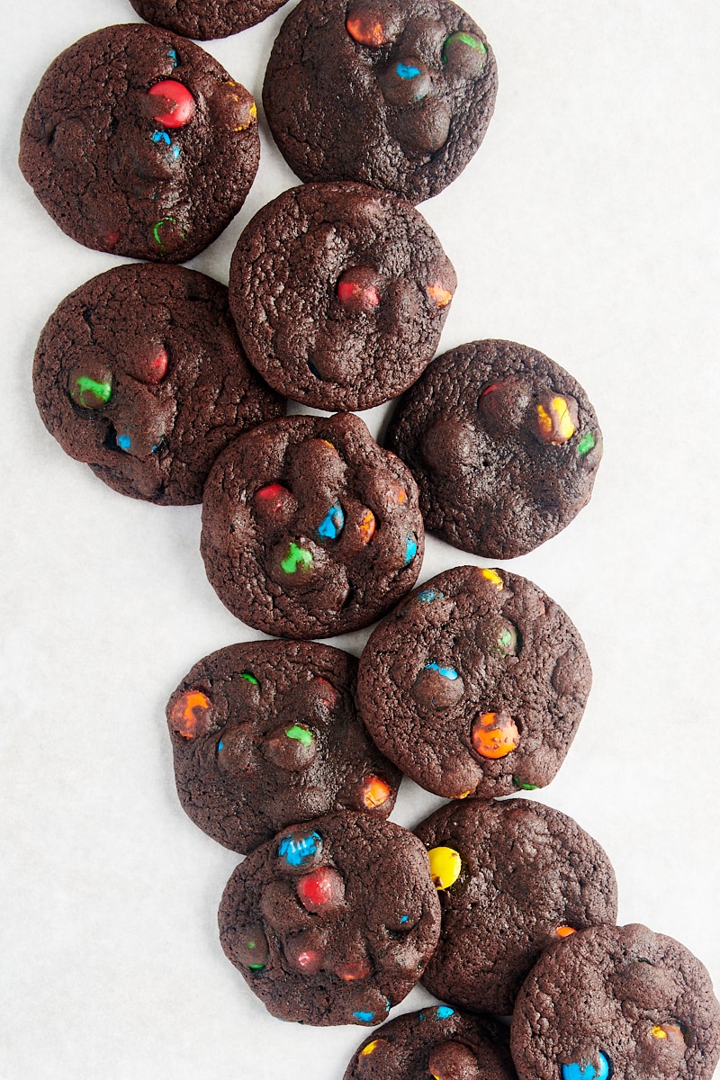 ovenfra av Chocolate M&M Cookies spredt over en hvit overflate
