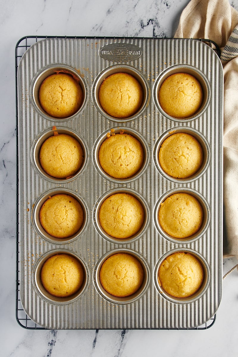 Cooked corn mufifins cooling in a muffin tin.