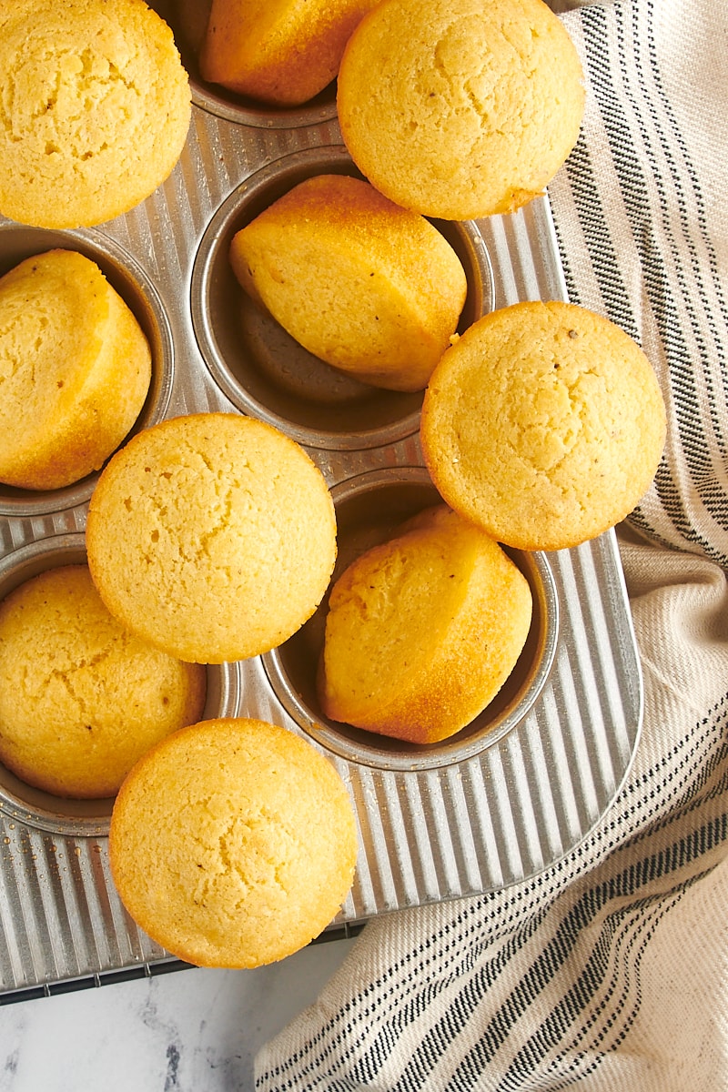 Corn muffins sitting on a muffin tin.