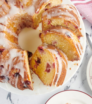 Cranberry bundt cake with slices missing.
