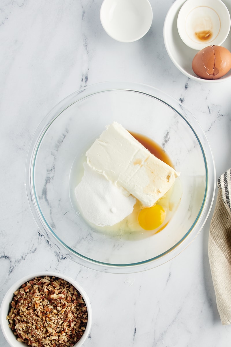 A bowl with cream cheese, egg, sugar, and vanilla.