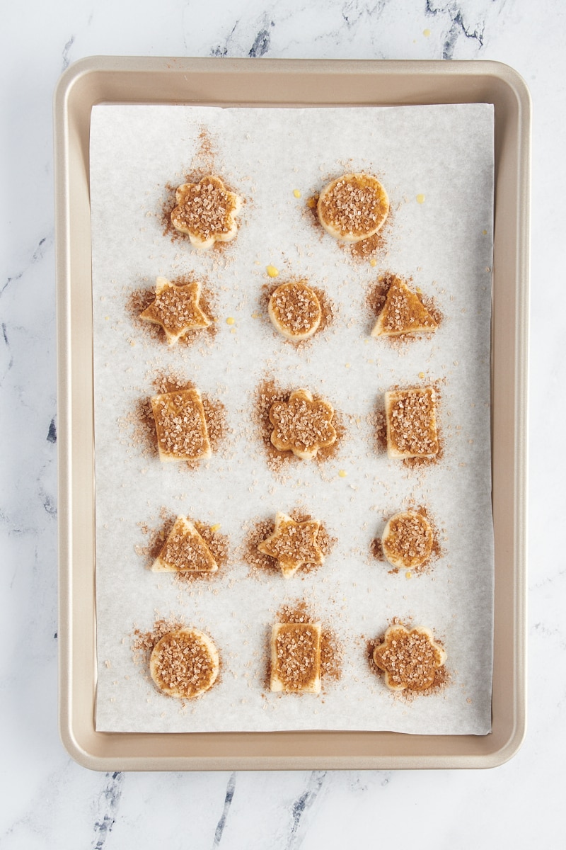 vista aérea de biscoitos de crosta de torta em uma assadeira forrada de pergaminho pronta para o forno