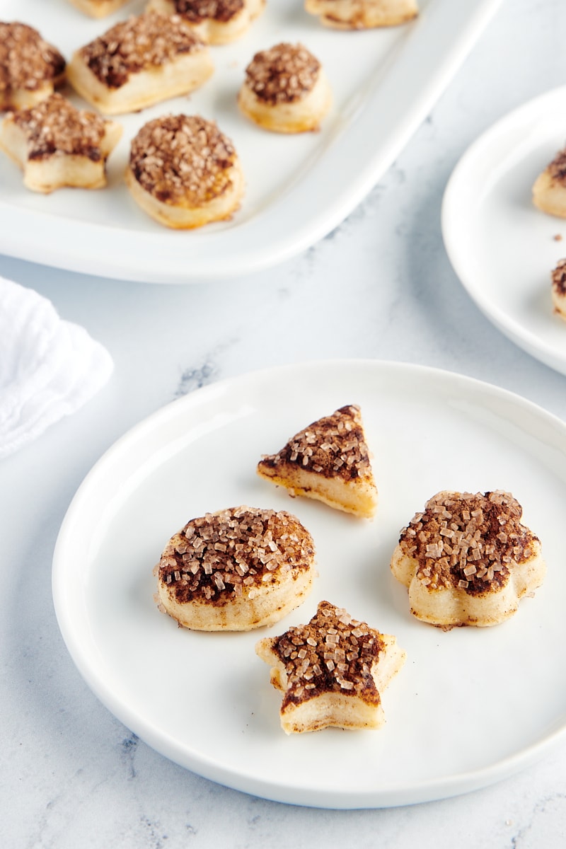 four Pie Crust Cookies on a white plate with more cookies in the background