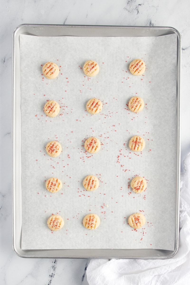 Overhead view of scooped shortbread cookie dough on a baking sheet.