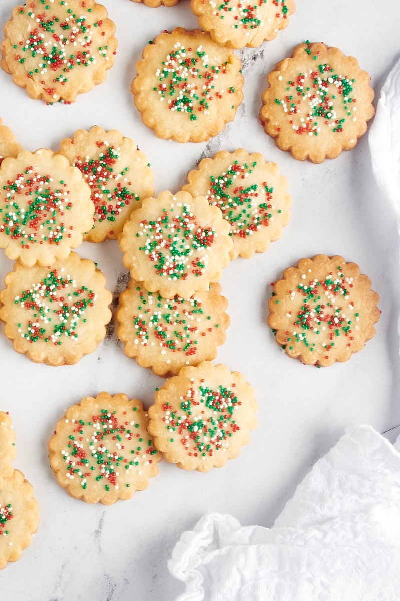 Overhead view of cutout shortbread cookies scattered on a countertop.