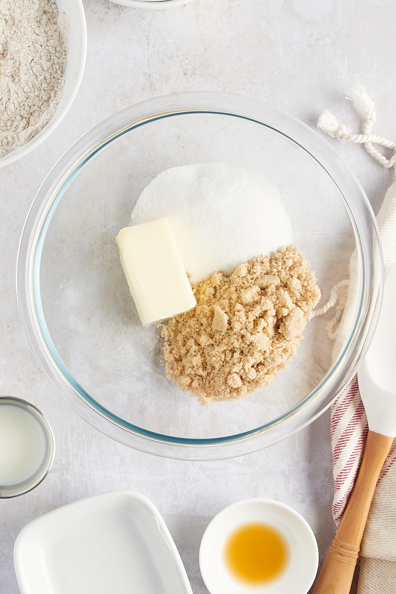 overhead view of butter, sugar, and brown sugar in a glass mixing bowl