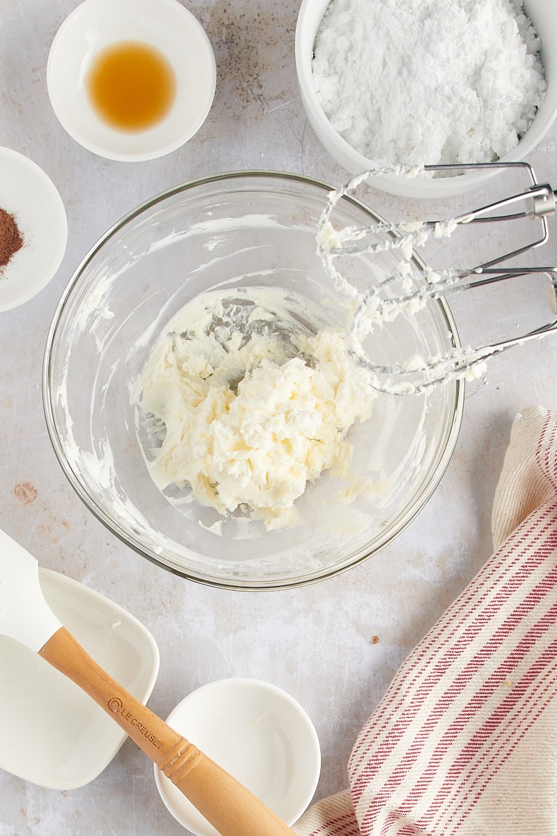 overhead view of mixed cream cheese and butter in a glass mixing bowl