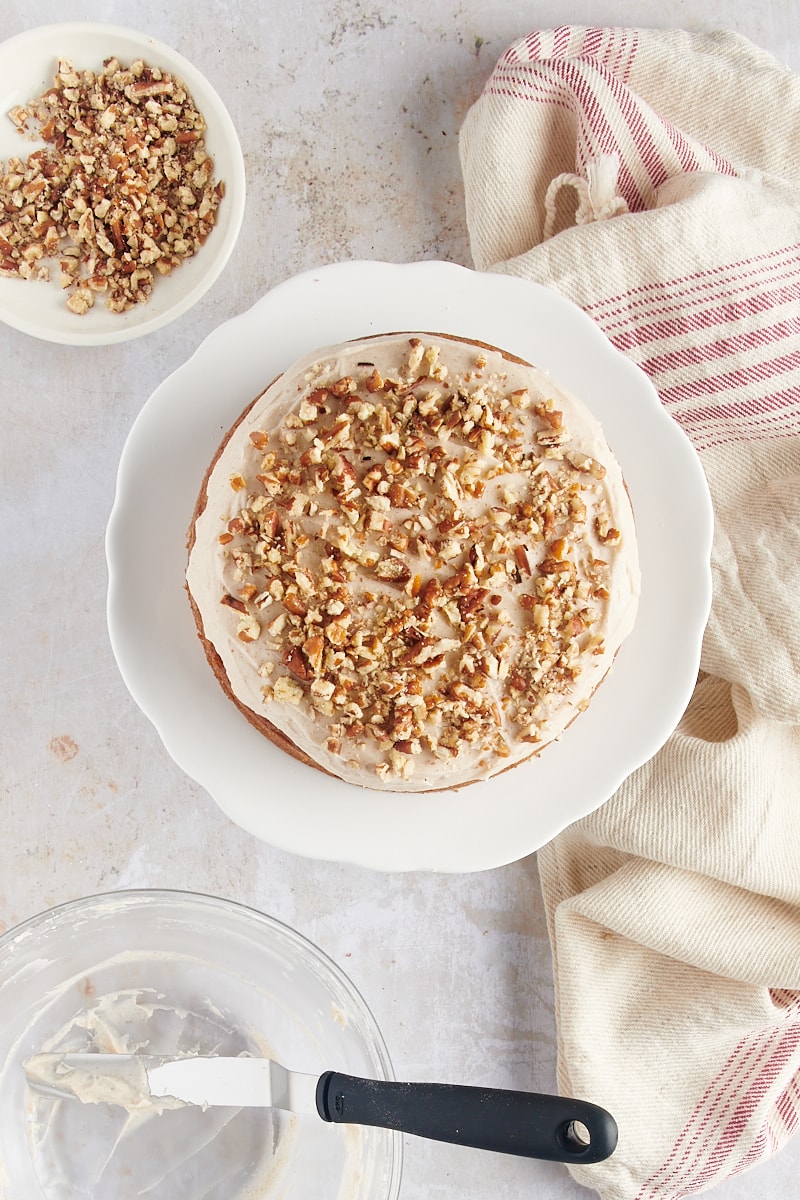 overhead view of frosted spice cake topped with chopped nuts