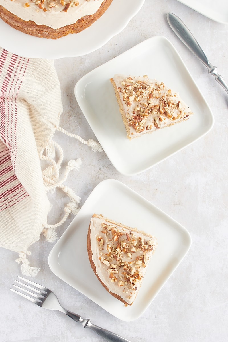 overhead view of two slices of spice cake on square white plates