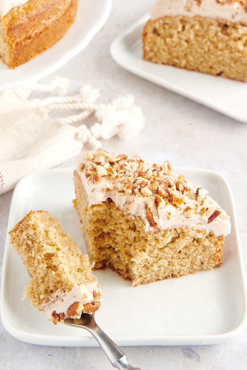 slice of spice cake on a white plate with a bite of cake on a fork