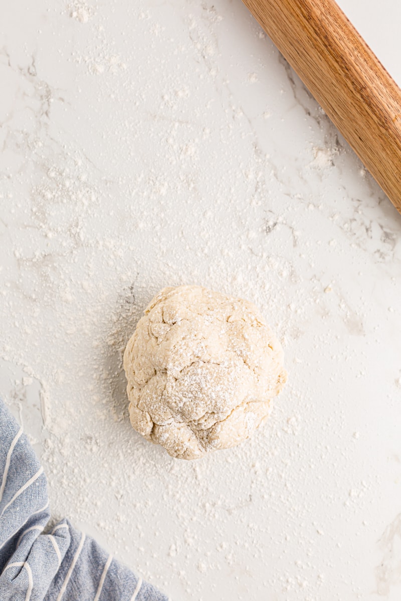 Ball of biscuit dough on a floured surface