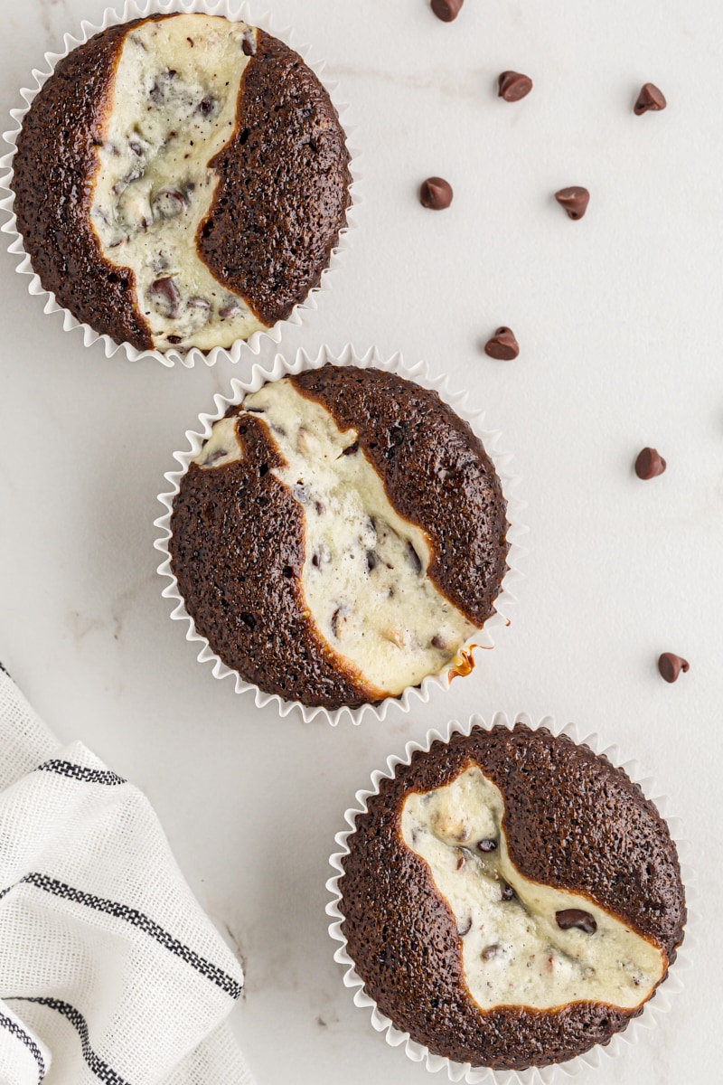 three Black Bottom Cupcakes on a marble surface