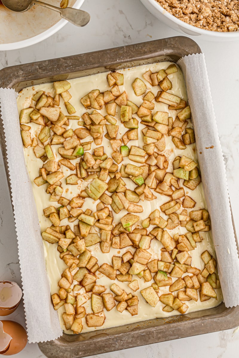 overhead view of cinnamon apples sprinkled over cheesecake filling
