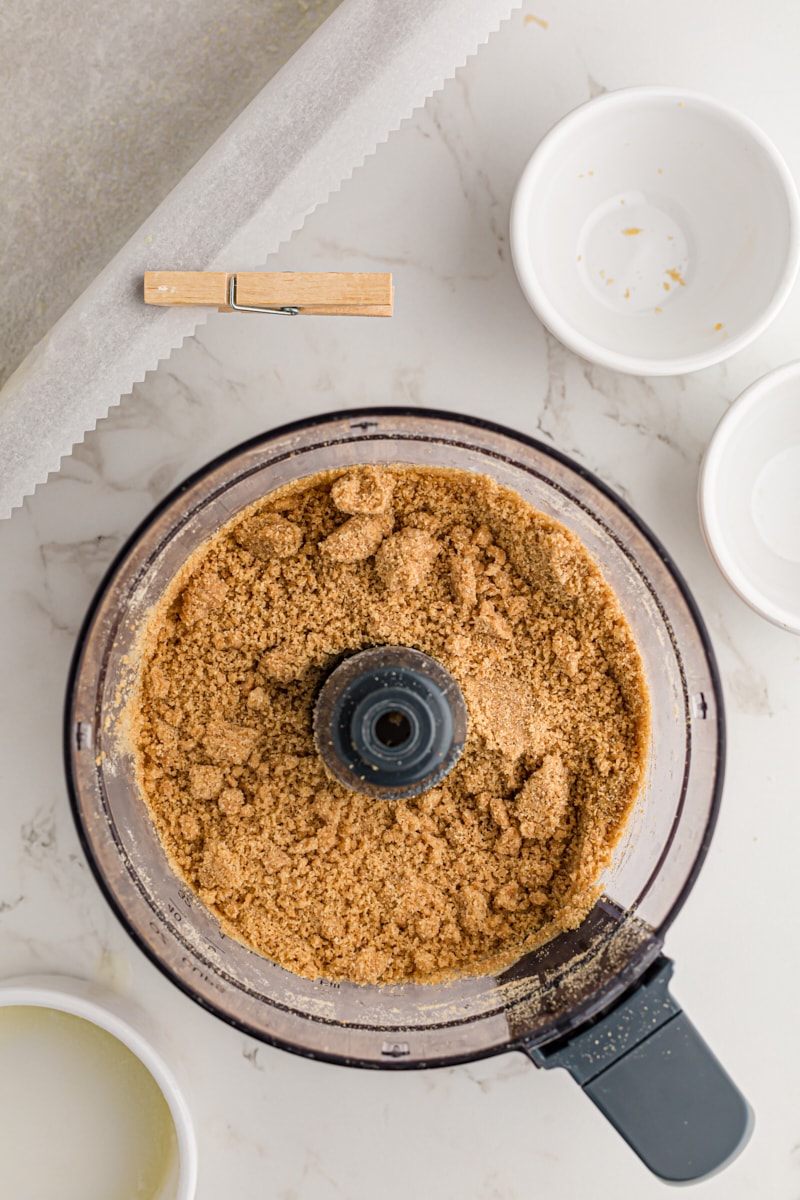 overhead view of mixed graham cracker crust mixture in a food processor