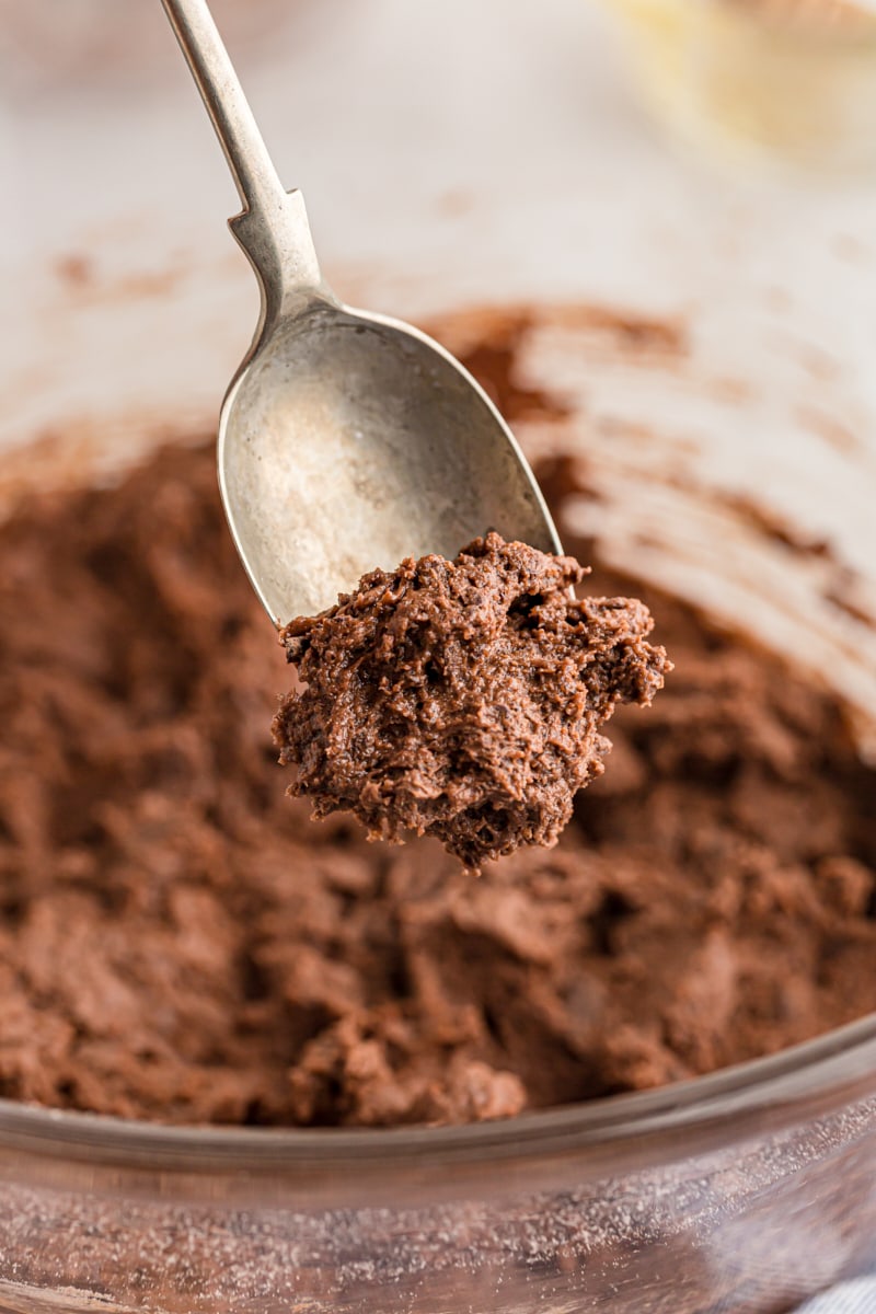 Scooping brownie cookie dough from bowl