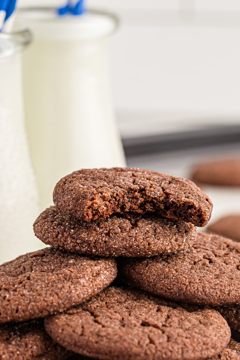 Stack of Double Chocolate Brownie Cookies with milk jugs in background