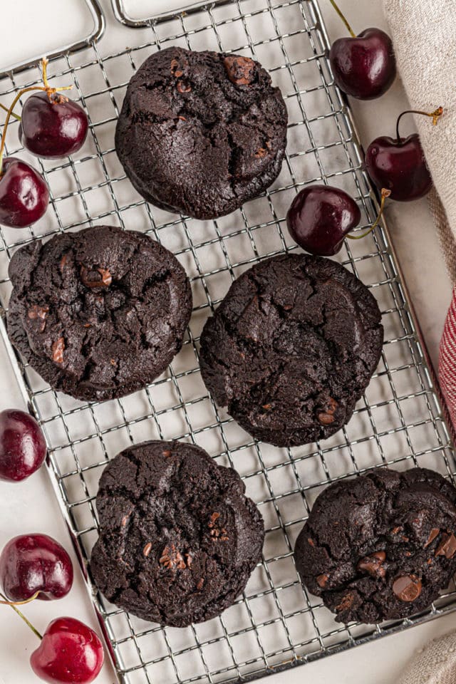 Overhead view of double dark chocolate cherry cookies on a wire rack.