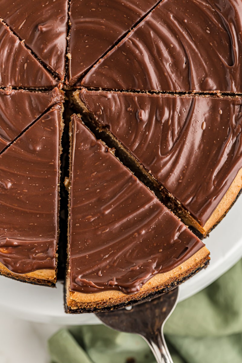 Overhead view of cut Peanut Butter Cup Cheesecake with slice being removed