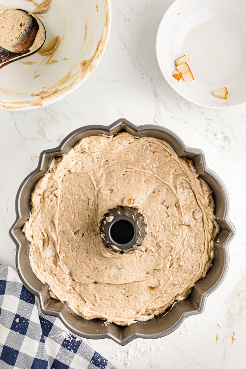 Spiced pear cake batter in the prepared bundt cake pan.