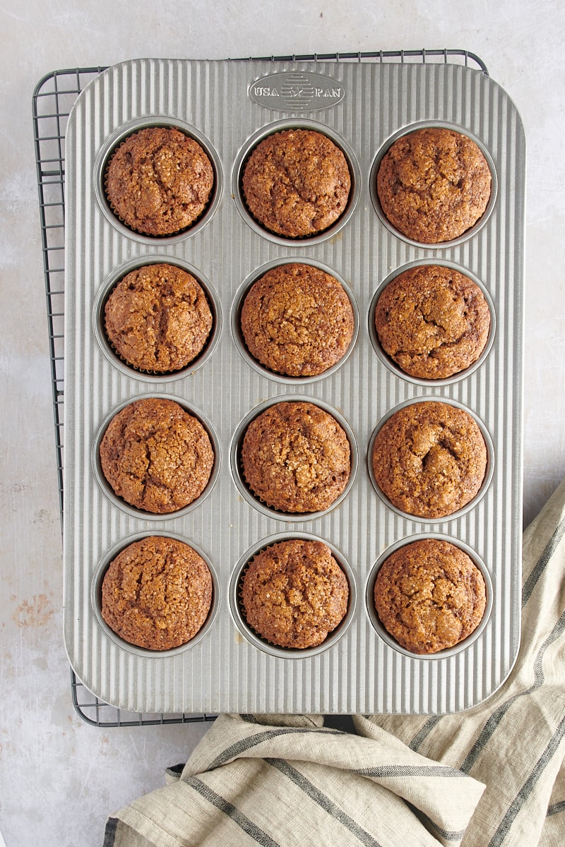 overhead view of freshly baked Gingerbread Muffins in a muffin pan on a wire rack