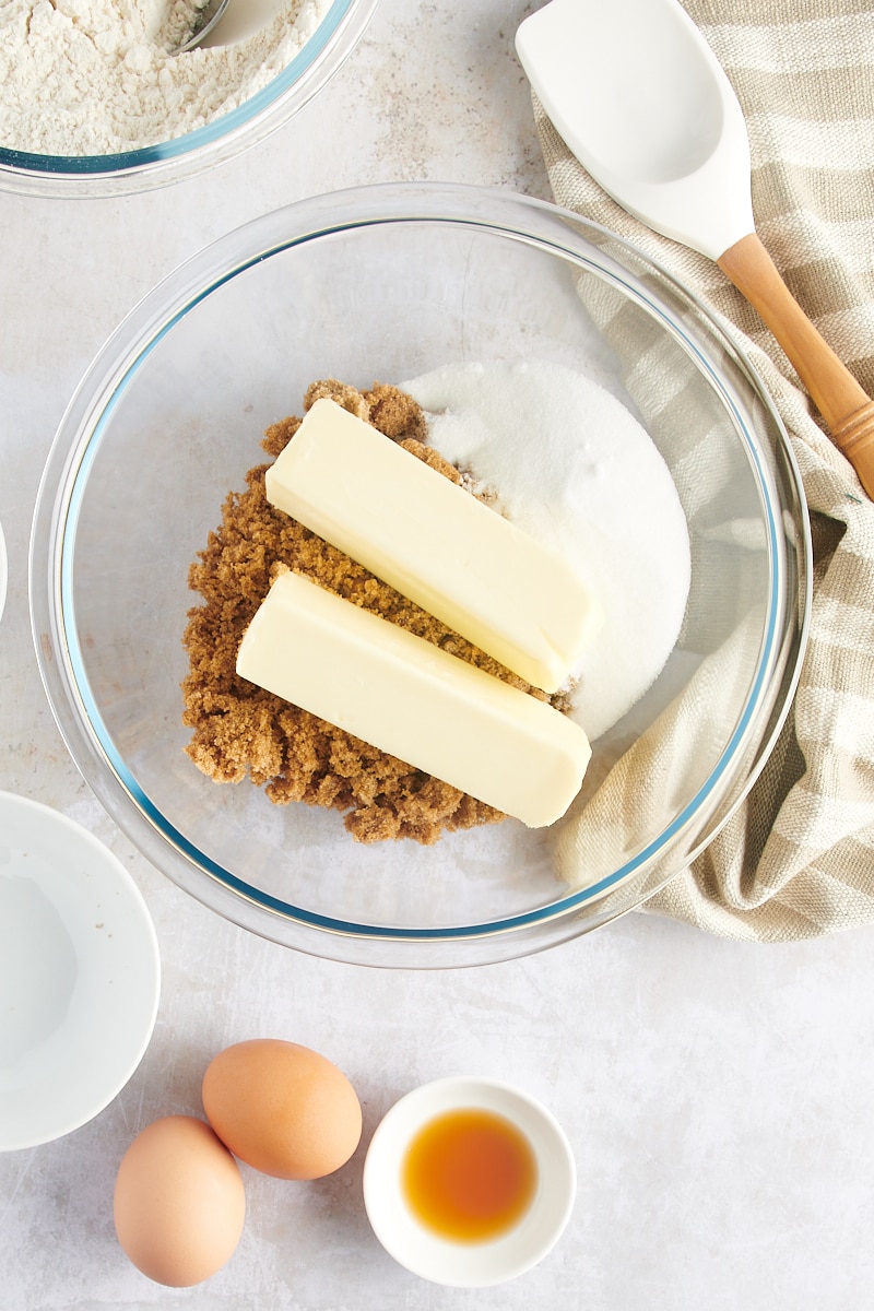 overhead view of butter, brown sugar, and sugar in a glass mixing bowl