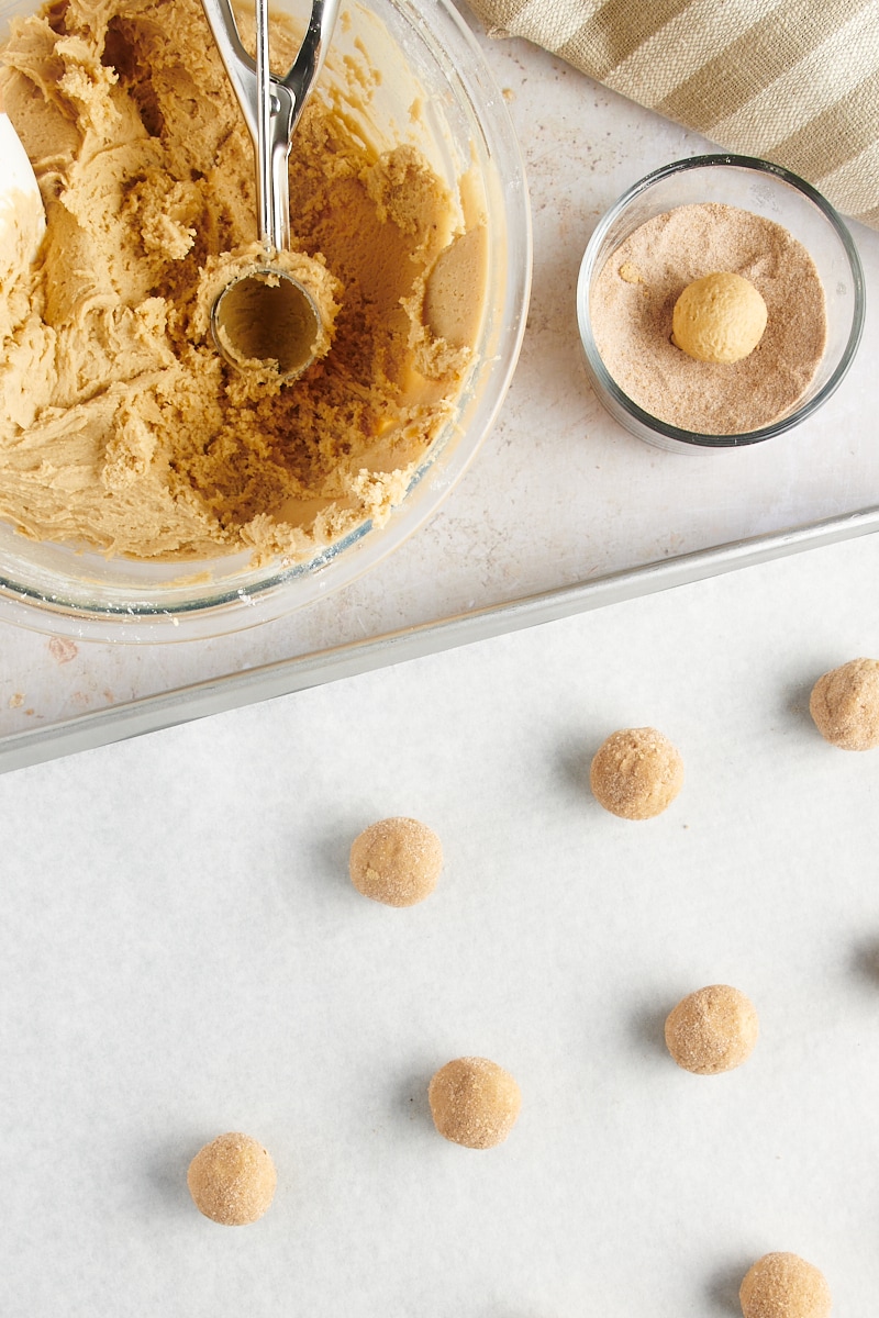 overhead view of Gingerdoodle Cookie dough being rolled into balls and coated in spiced sugar