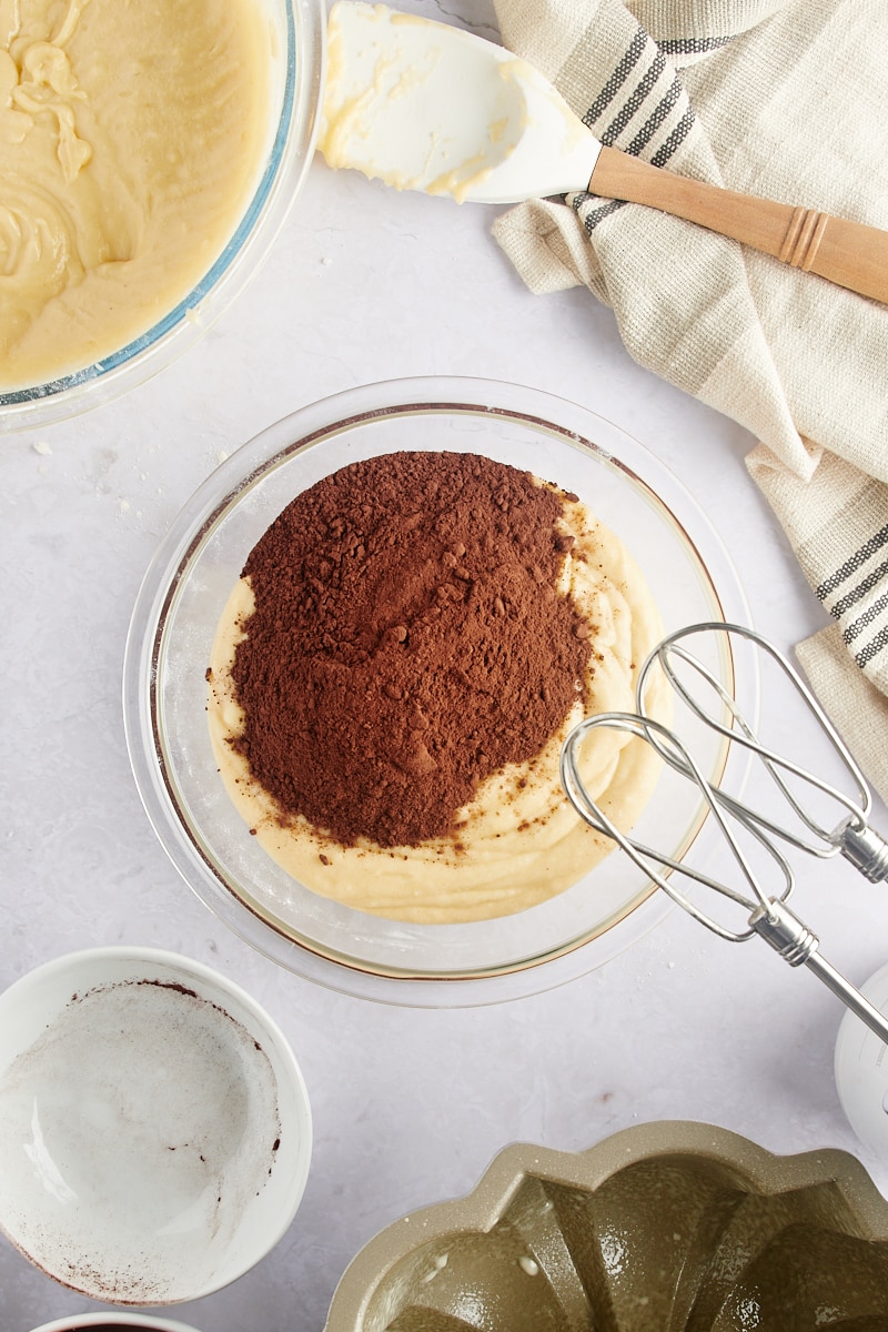 overhead view of cocoa powder added to cake batter