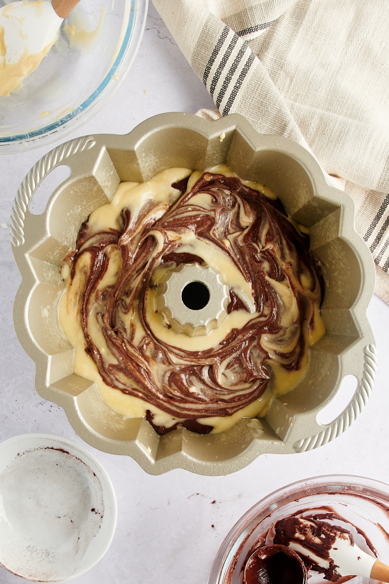 horný pohľad na Marble Bundt Cake cestá víriace spolu v Bundtovej panvici