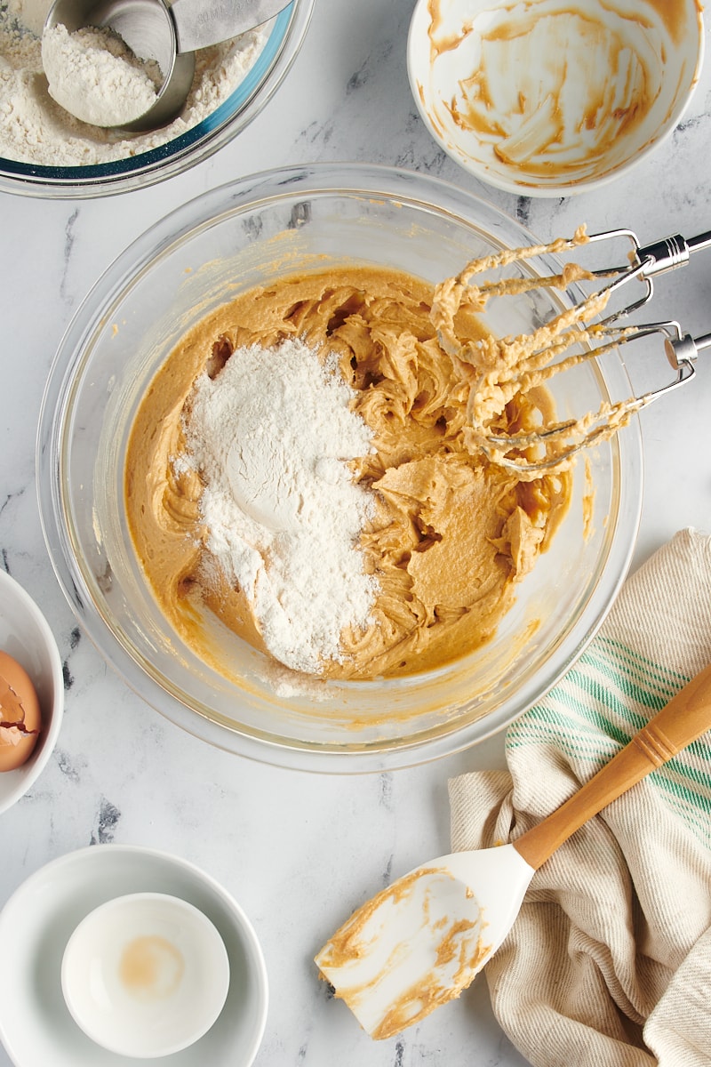 overhead view of dry ingredients added to peanut butter cookie dough