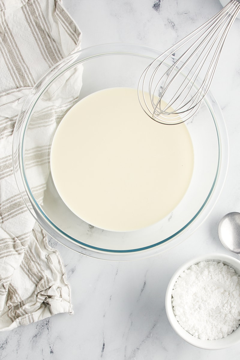 overhead view of heavy cream in a glass mixing bowl