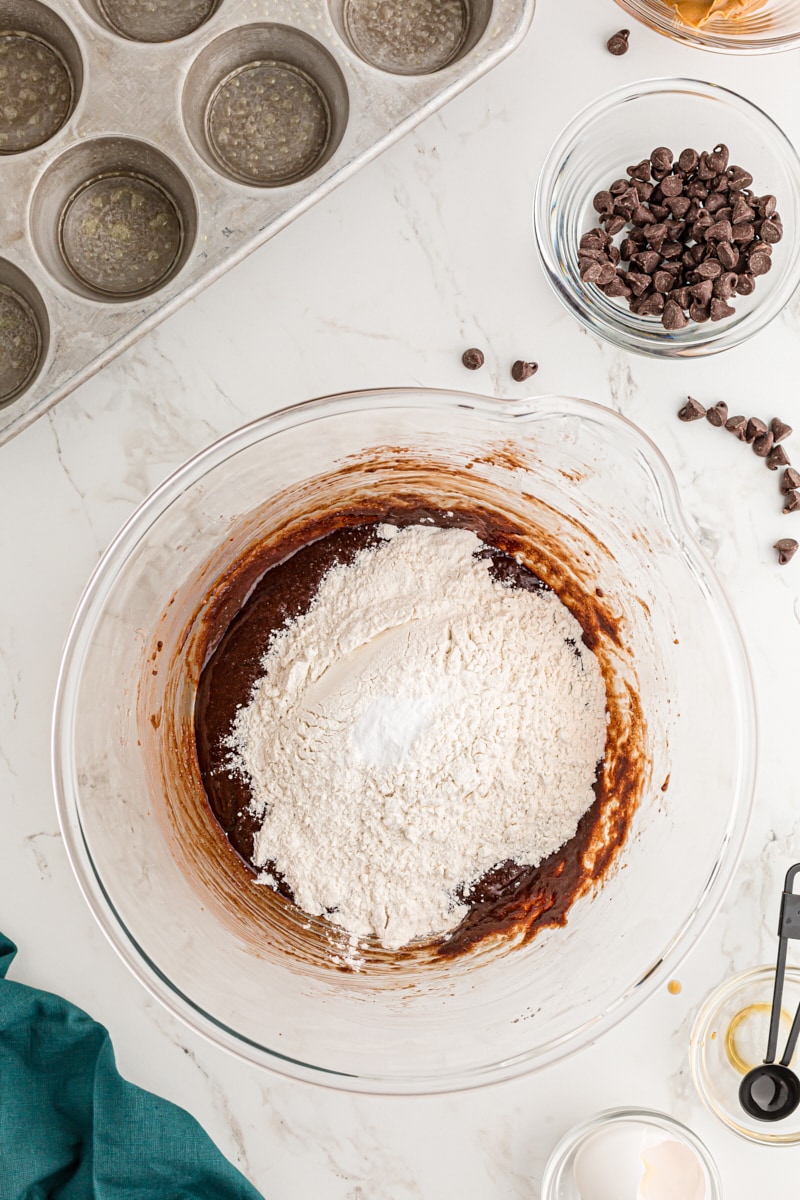 Overhead view of dry ingredients added to bowl of brownie batter