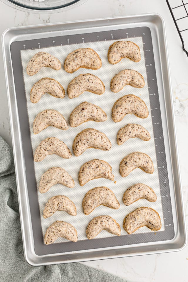 Overhead view of baked hazelnut crescents on baking sheet