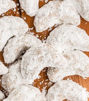 Overhead view of hazelnut crescent cookies on wooden board