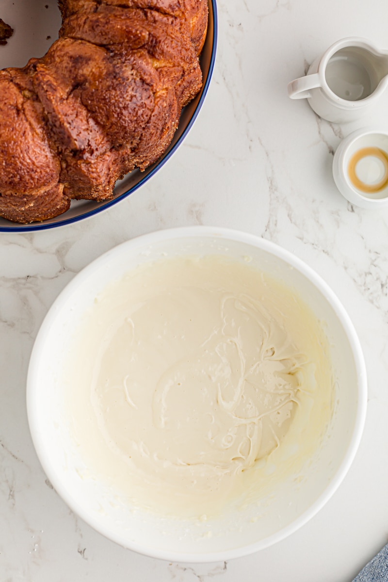 overhead view of cream cheese icing in a white mixing bowl