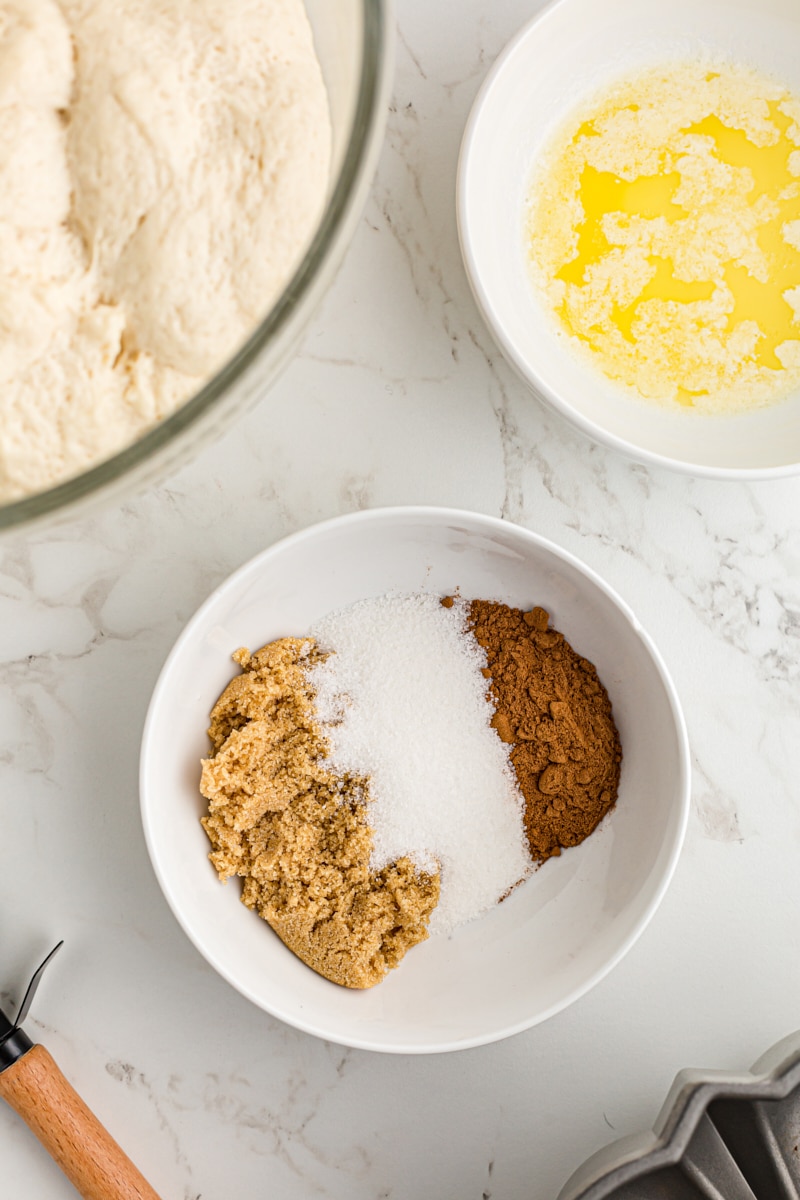 overhead view of sugar, brown sugar, and cinnamon in a white bowl