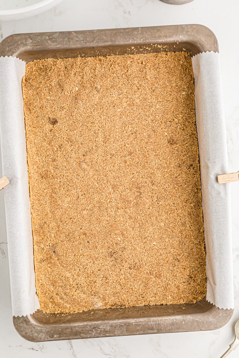 Overhead view of graham cracker crust in 9x13 pan