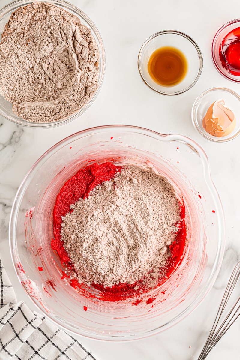 overhead view of dry ingredients added to wet ingredients for Red Velvet Cookie dough