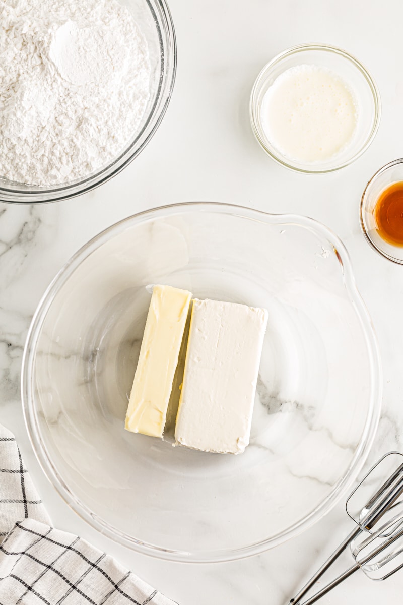 overhead view of butter and cream cheese in a glass mixing bowl