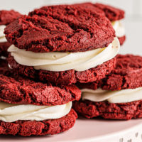 Red Velvet Cookies stacked on a light pink pedestal